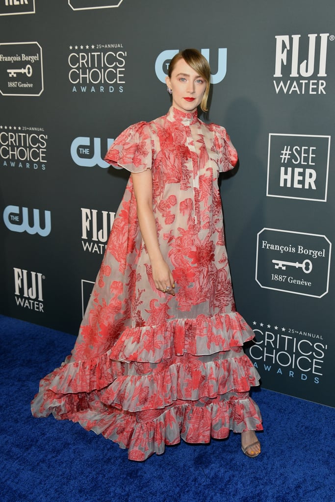 Saoirse Ronan seems to have taken some outfit inspiration from her Little Women character Jo March at the Critics' Choice Awards on Sunday. Ronan walked the blue carpet in a ruffled 1800s-inspired gown from Erdem's Spring 2020 Ready-to-Wear collection, and it featured one cheeky detail that Jo would be proud of: it's secretly sheer. At first glance, the gown, which features an elegant floral print, seems to be the picture of sophistication, and it is — with a twist. 
Ronan paired the look with a honey yellow manicure and colourful rings that truly make the coral-coloured embellishments on the gown pop. Something tells us that brave, bold, and daring Jo would love to take a twirl in this stunning gown. Take a closer look at Ronan's dress from all angles ahead.

    Related:

            
            
                                    
                            

            Zendaya at the Critics&apos; Choice Awards Has Nourished My Essence for Years to Come