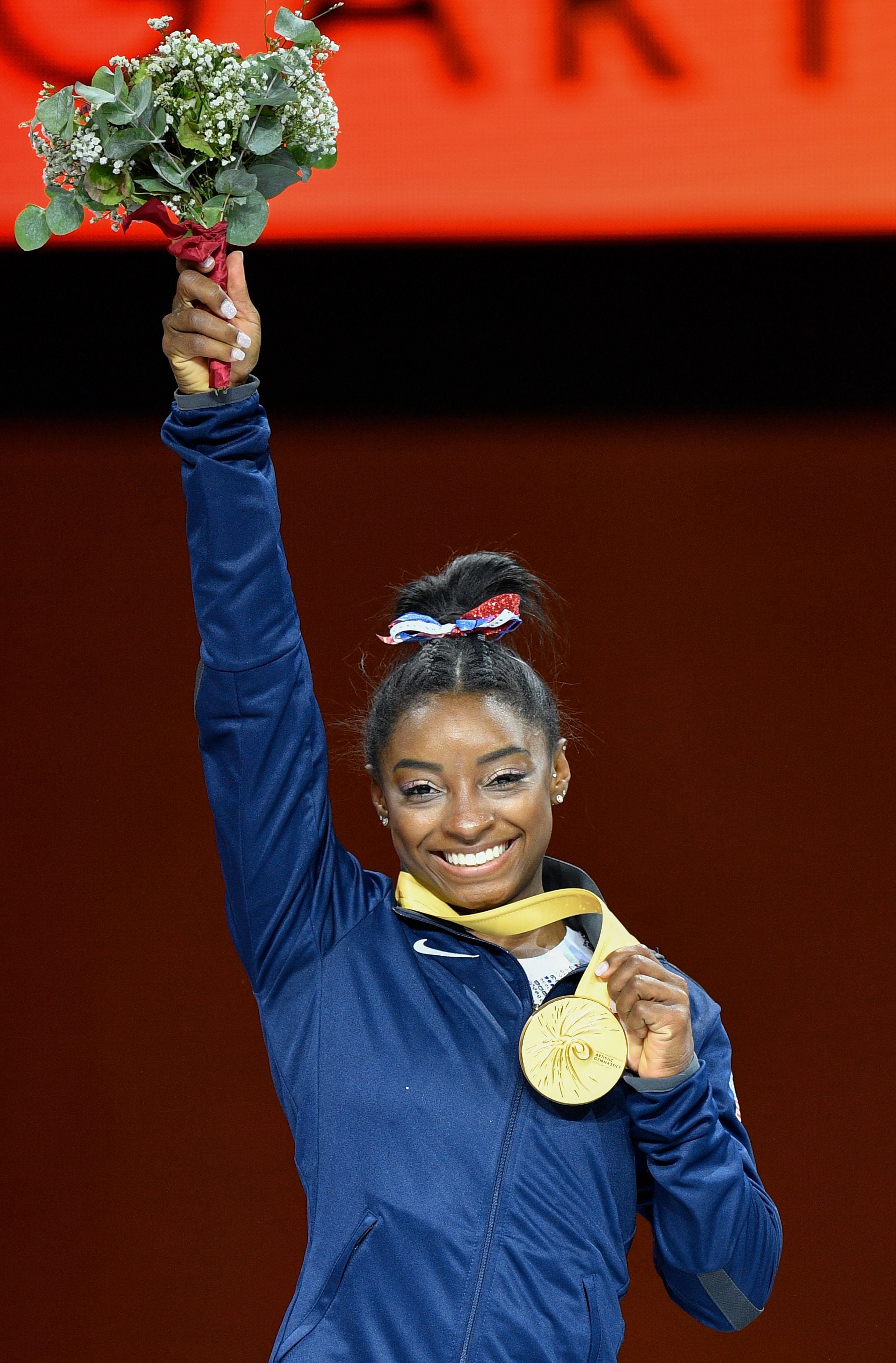 USA's Simone Biles poses on the podium during the medals ceremony of the womens all-around final at the FIG Artistic Gymnastics World Championships at the Hanns-Martin-Schleyer-Halle in Stuttgart, southern Germany, on October 10, 2019. - USA's Simone Biles won Gold ahead of China's Tang Xijing (Silver) and Russia's Angelina Melnikova (Bronze). (Photo by Thomas KIENZLE / AFP) (Photo by THOMAS KIENZLE/AFP via Getty Images)