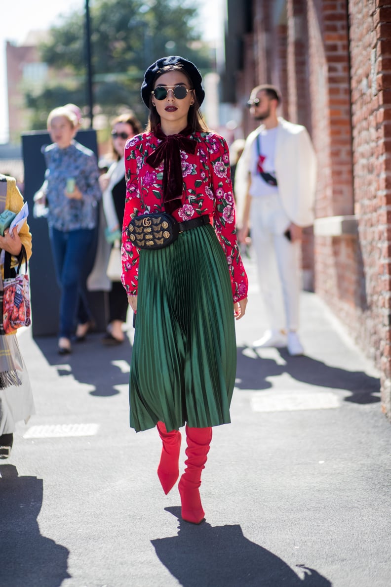 Style One With a Pleated Skirt, a Floral Blouse, and Red Boots