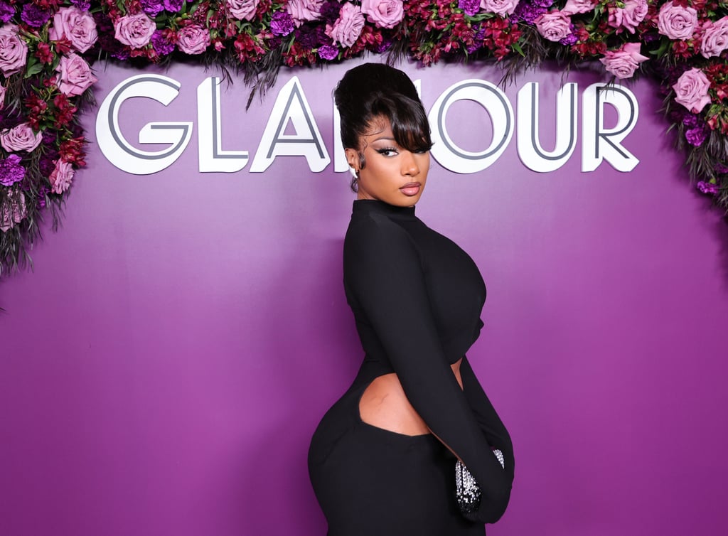 Megan Thee Stallion was honoured as one of Glamour's Women of the Year at the magazine's celebration Monday night, so it was only appropriate that she wore a look fit for a winner. The rapper stunned in a slinky black turtleneck dress with attached gloves, showing skin by way of an asymmetrical cutout across the waist and sleeves. How good is this architectural approach to a classic gown?
Emmy Award-winning costume designer Zerina Akers styled Megan's custom Mônot look, from the brand's spring 2022 collection, with eight-carat diamond earrings by Vhernier, a jewel-encrusted clutch, and matching sparkly heels. Lori Harvey also recently wore a similar blush-worthy dress from Mônot for her SKN by LH launch party, offering some sizable hip cutouts and thigh slits. 
"The thing I love most about Meg is how she's covered in confidence, dripping in it so much that you can't help but to pick some up for yourself along the way," Zerina wrote alongside photos of the artist at the event. We couldn't have described Megan's style better ourselves. Get a closer look at the sleek dress ahead. 

    Related:

            
            
                                    
                            

            Megan Thee Stallion Celebrated "Hottieween" in a Skin-tight Fairy Costume (Wings Included)