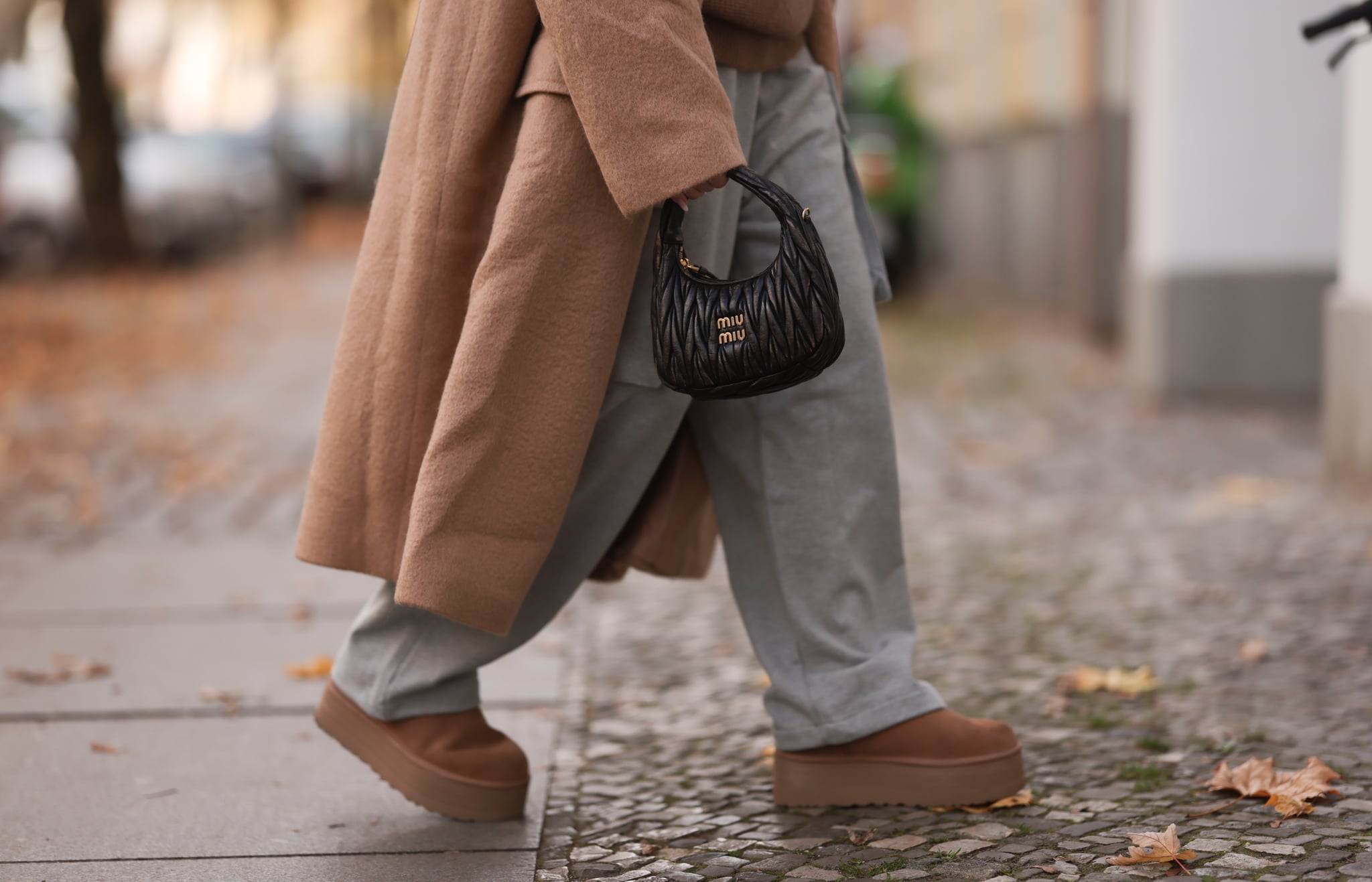BERLIN, GERMANY - NOVEMBER 10: Sonia Lyson seen wearing a The Frankie Shop beige oversized coat and grey joggingpants pants, a Lala Berlin beige knit turtleneck sweater, Ugg plateau ultra mini beige boots and a Miu Miu Wander Hobo brown leather bag on November 10, 2022 in Berlin, Germany. (Photo by Jeremy Moeller/Getty Images)