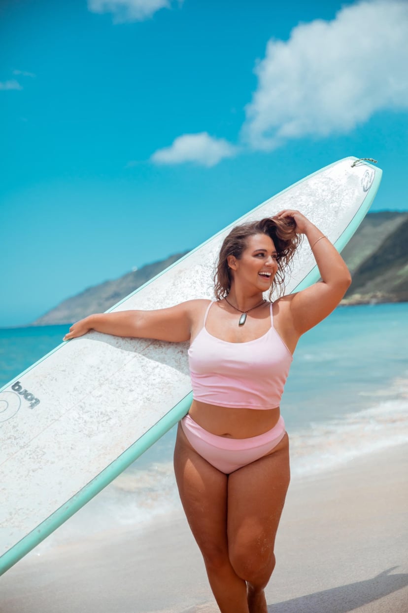 curvy surfer girl holding surf board