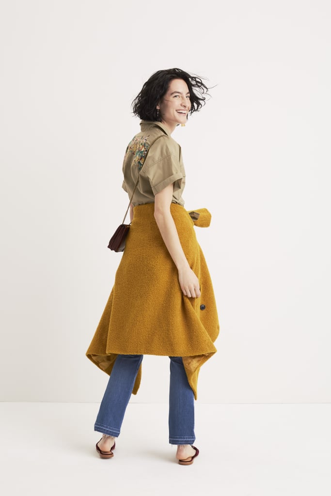 A mustard yellow coat adds color to an otherwise muted outfit