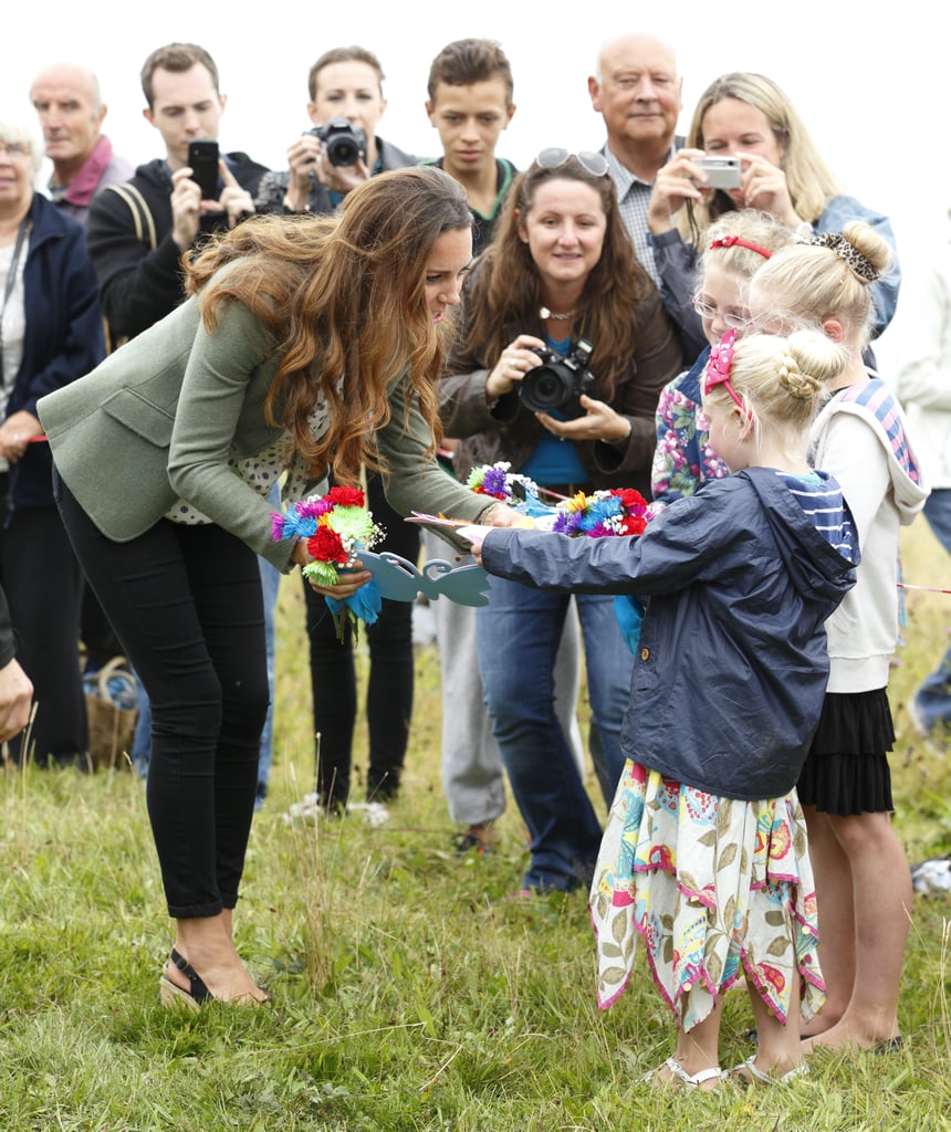 While visiting locals in Holyhead, Wales in August 2013, Kate was given posies.