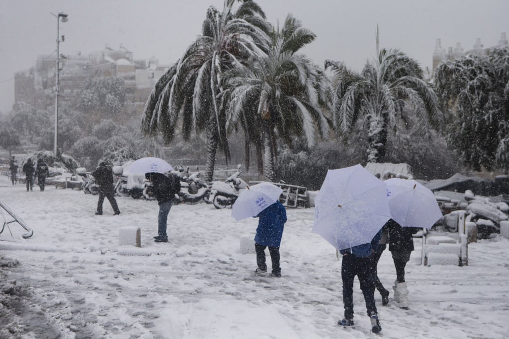 People carried umbrellas to walk through the snow near Damascus gate in Jerusalem.