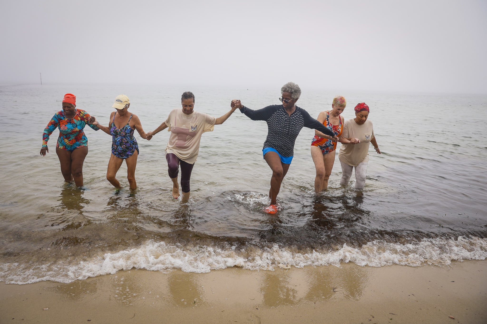 Peggy Barmore, center, an Inkwell Polar Bear for over 20 years, leads the bears out of Inkwell Beach in Oak Bluffs after their exercise.