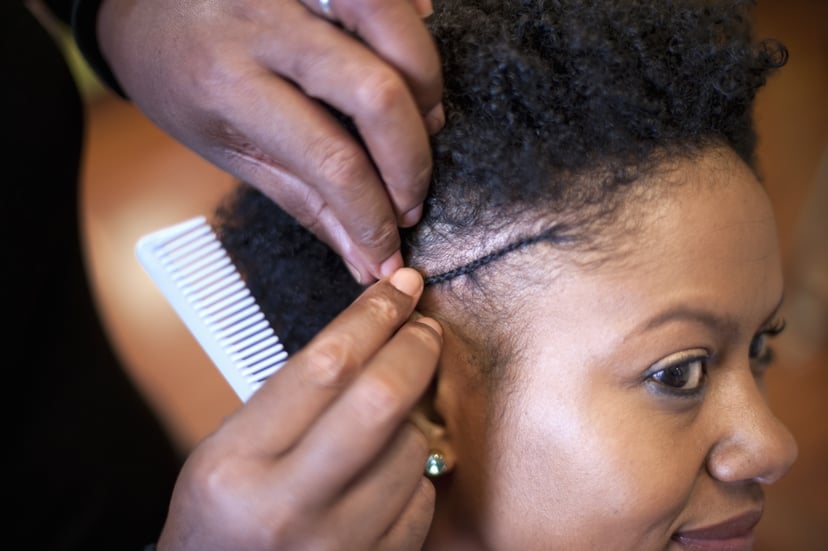 hair stylist braiding woman's hair