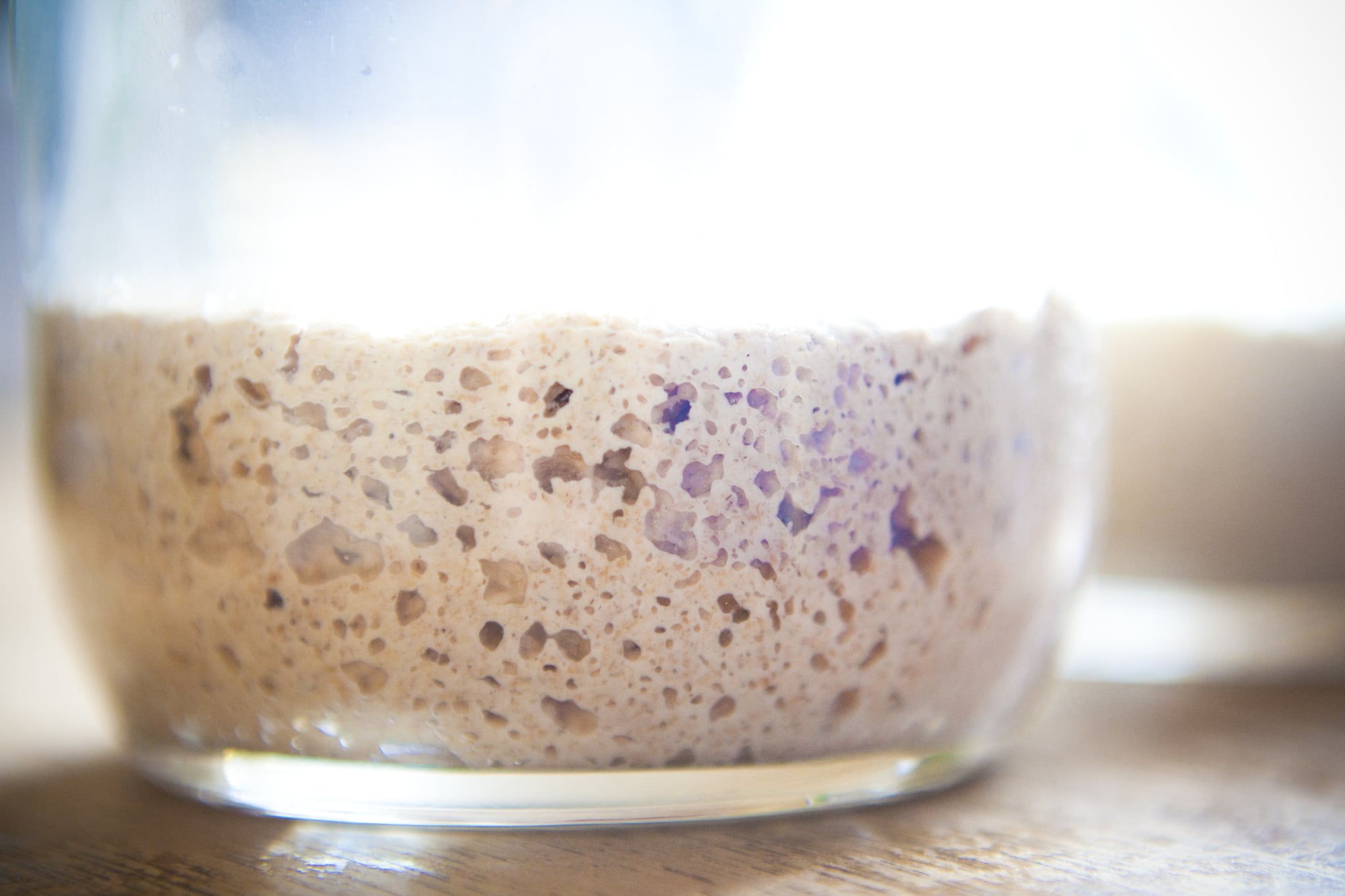 Glass of fermenting sourdough starter for making tasty bread.