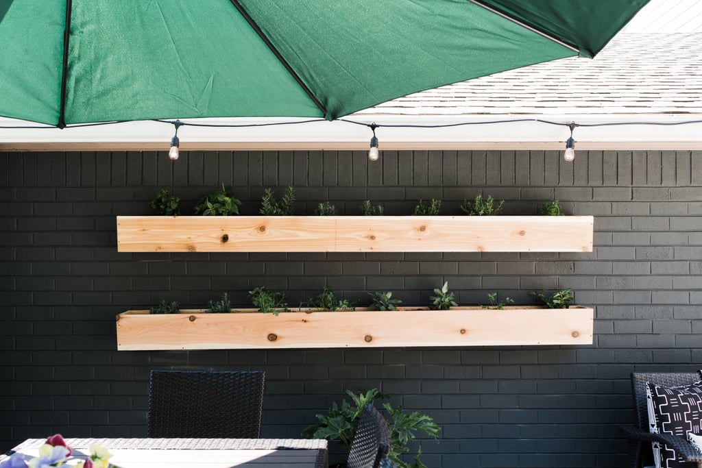 Monica wanted to make the deck a veritable outdoor kitchen, so beyond throwing a grill onto it, she added an herb garden. Using wooden boards, Monica built and mounted long horizontal planters on the wall and filled them with fragrant herbs, perfect for cooking.