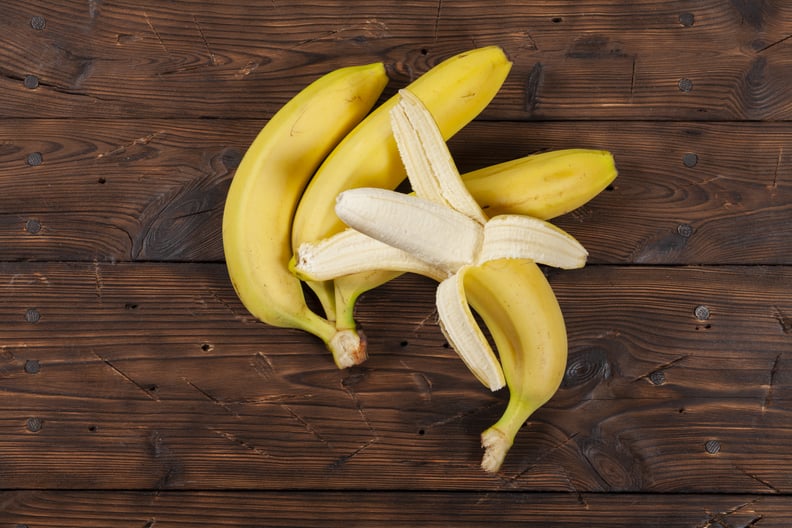 Fresh and ripe yellow bananas lie on an old wooden desk.