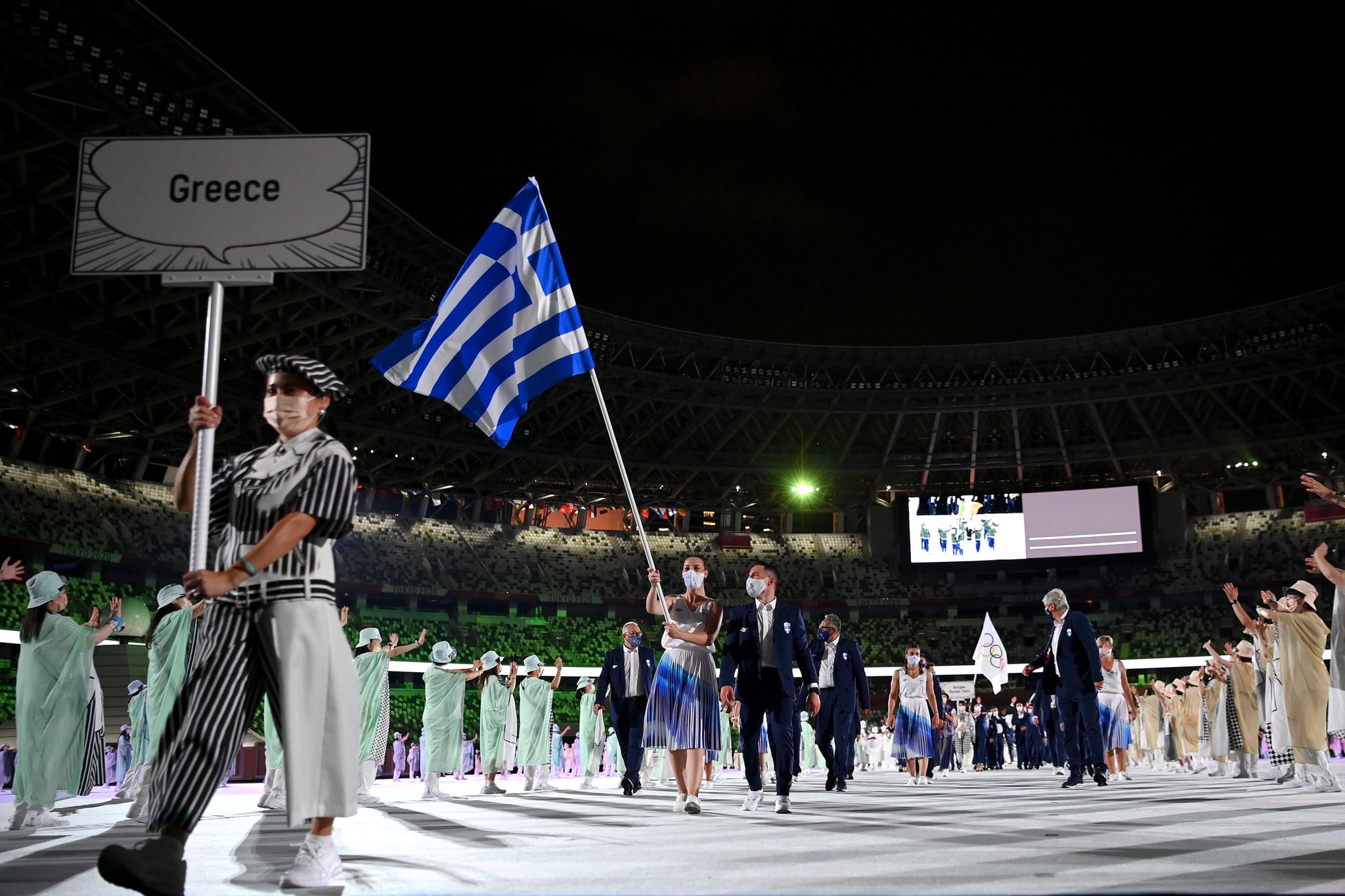 TOKYO, JAPAN - JULY 23: Flag bearers Anna Korakaki and Eleftherios Petrounias of Team Greece lead their team in during the Opening Ceremony of the Tokyo 2020 Olympic Games at Olympic Stadium on July 23, 2021 in Tokyo, Japan. (Photo by Matthias Hangst/Getty Images)