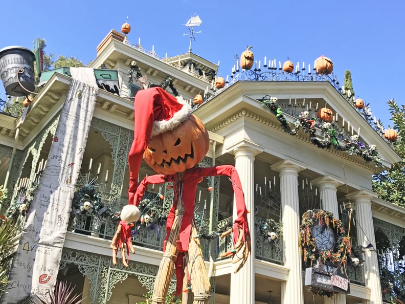 A spooky scarecrow greets you in line.