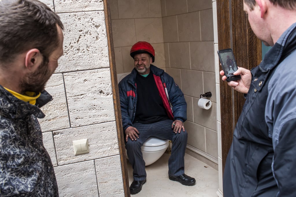 A man posed for a picture on one of the toilets at the estate.