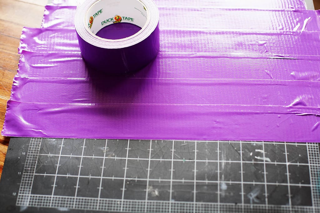 Along with our Baymax costume, I'm sharing 88+ more really awesome handmade costume ideas from talented bloggers everywhere!
We often make fun costumes using solid t-shirts, shorts/pants, paper, and duct tape. I love combining these materials to get lots of different looks!
For suited-up Baymax, you'll need a red shirt, pants/shorts, purple duct tape, red paper, white paper, elastic string, and a black marker. For the shirt "plate," I covered a self-healing mat with duct tape (I LOVE using these mats to cut duct tape because you can stick it on and it comes right back off).