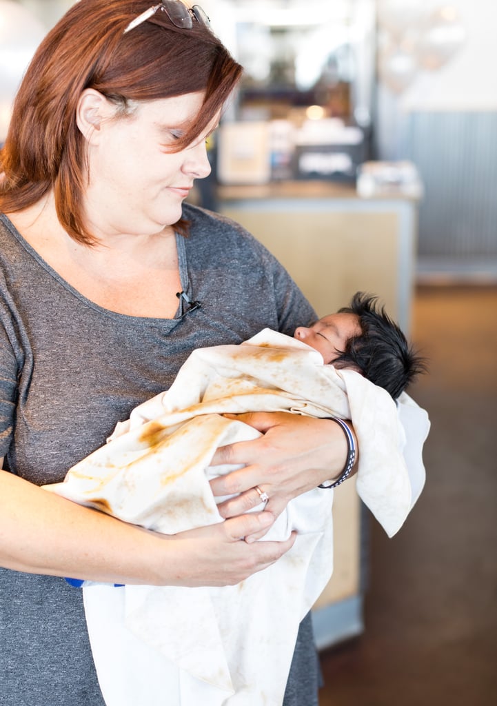 Angie holding baby Jaden in his theme-appropriate burrito swaddle blanket.