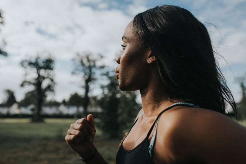 Close up of a woman jogging through a park in the morning. 