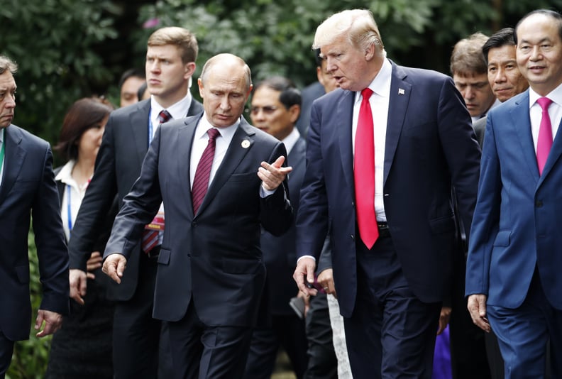 US President Donald Trump (R) and Russia's President Vladimir Putin chat as they walk together to take part in the 