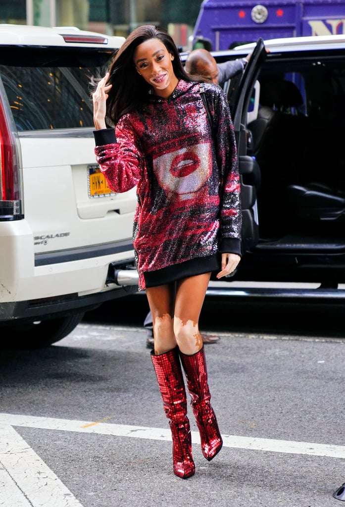 Winnie Harlow rocking a sweater dress with sequined thigh-high boots.