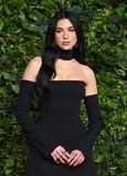 Dua Lipa Pirouettes in a Backless “Frock” and Knee-High Boots