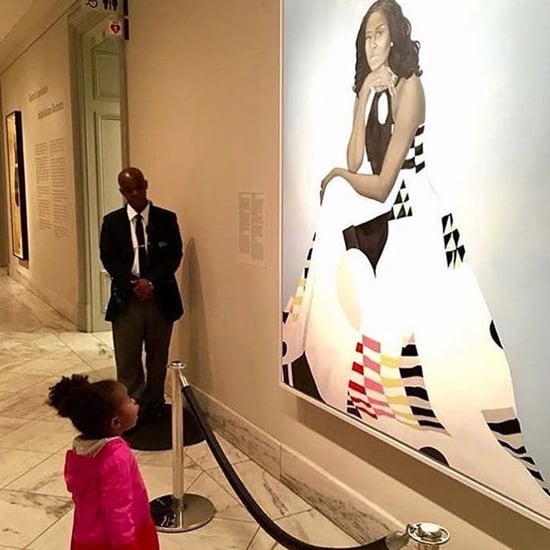 Little Girl Looking Up at Portrait of Michelle Obama
