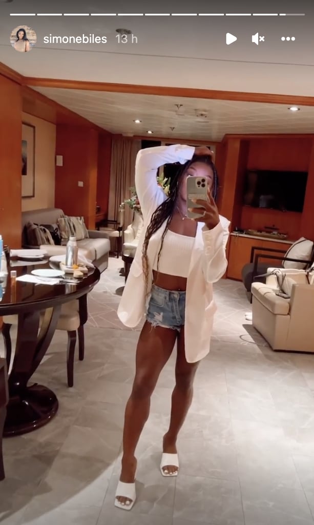 Simone Biles brought her sartorial A game on vacation in Turks and Caicos, which she has been documenting on Instagram. Her latest style moment revolves around some timeless warm-weather staples, suggesting the gymnast is still holding onto summer. In a mirror selfie posted on her Instagram Story, Biles showed off a dressy-casual outfit consisting of blue denim shorts and a white crop top. 
She layered it under a white blazer, which she left unbuttoned for a relaxed and semiprofessional look. Her medium-wash cutoffs conveyed an edgy vibe with frayed hems and light rips. Committing to the white palette with her footwear, she added square-toe mules, her pedicure also on theme. To finish, a pair of rings and dainty chain necklaces rounded out the summer-ready look. 
Biles has been switching from swimsuits to warm-weather separates throughout her tropical getaway. Just a day earlier, she posed in a high-waist bikini imprinted with a colorful mural pattern, paired with a straw visor and a mock-neck crop top. The day before, she embraced summer's hottest swimwear trend, lounging on a beach cabana in a pink-and-orange halter thongkini. Biles has also been documenting her activities, from boat rides and sushi meals to silent disco parties with her friend Ali Tyler. It's clear the star isn't ready for summer to end, so you can expect her to continue serving everyday style inspiration as the season continues.
Ahead, re-create Biles's look with similar pieces.

    Related:

            
            
                                    
                            

            Simone Biles Strikes a Pose in a Colorful Bikini in Turks and Caicos