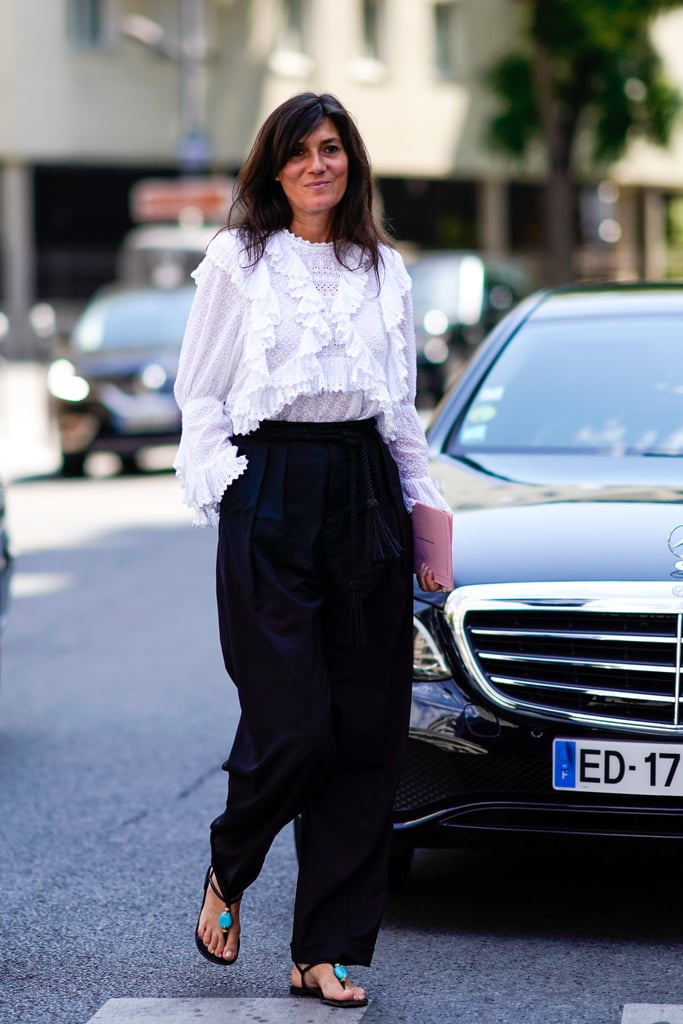 Emmanuelle Alt's Parisian chic take on high-waisted pants relies on a ruffled white blouse and bohemian sandals.