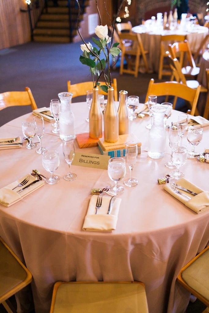 Pare down the flowers to a few budget-friendly stems by using gold-painted bottles and vintage books as your centerpiece.
Photo by Sara Lucero via Style Me Pretty
