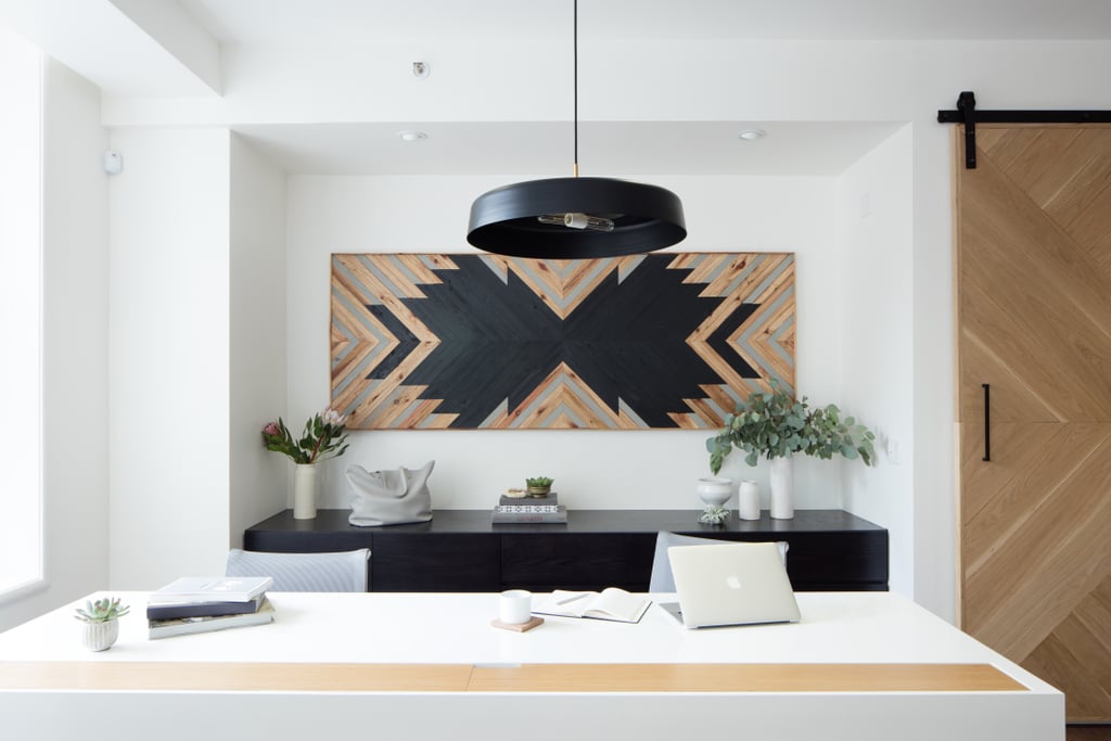Warm wood and glossy black and white accents play off each other on custom-made desks, art, and luxe lighting.
