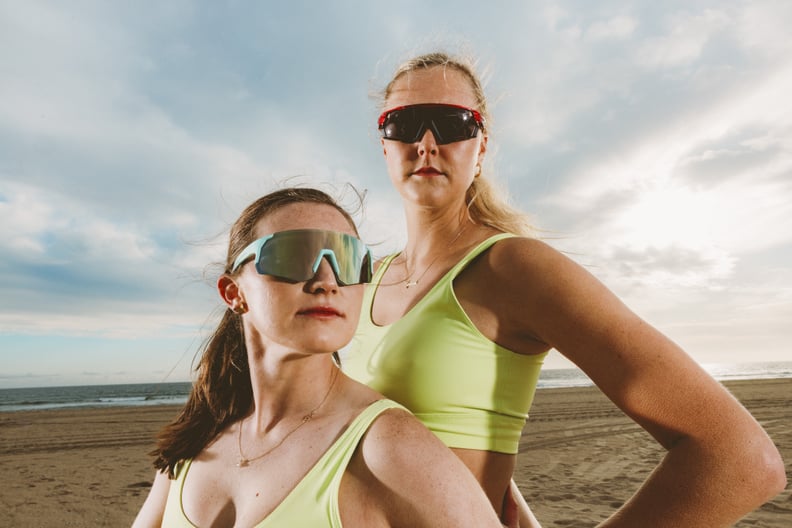 Kristen Nuss and Taryn Kloth posing by the beach in matching sports bras and Zenni Optical sunglasses.