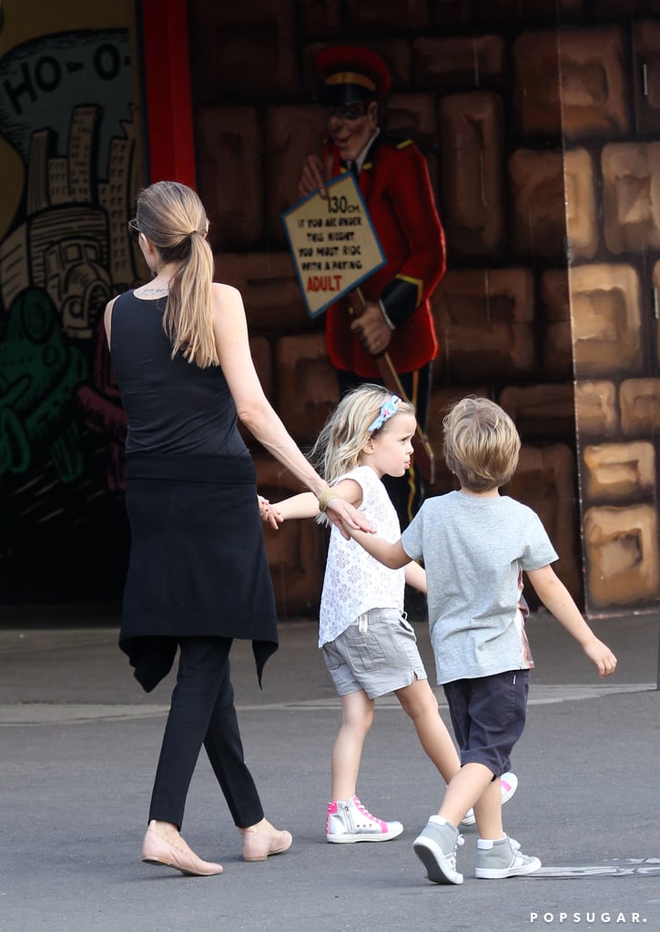 Angie held onto her twins' hands as they explored the park.