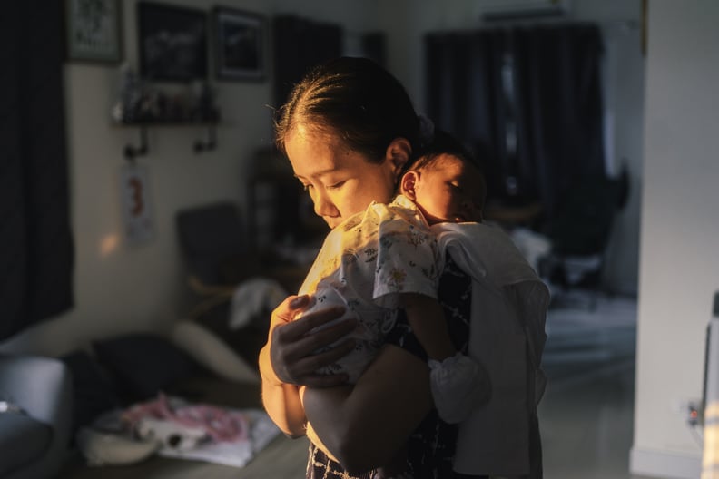 mom holding her newborn daughter at home