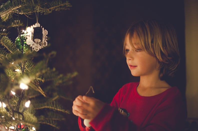 Little boy decorating a Christmas tree.