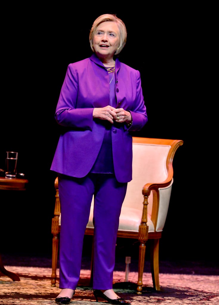 Giving a speech in a head-to-toe purple ensemble.