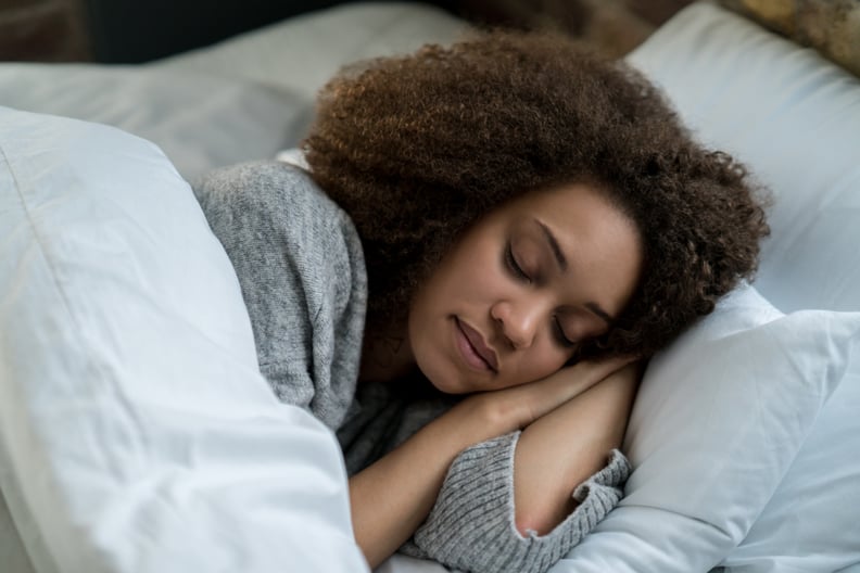 肖像的一个美丽的非洲裔美国妇女睡在床上,看起来非常和平,生活方式的概念”width=