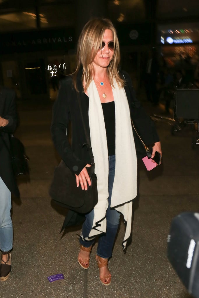 Jennifer catching a flight in LAX wearing a black tank top, jeans, and a white scarf in July 2016.