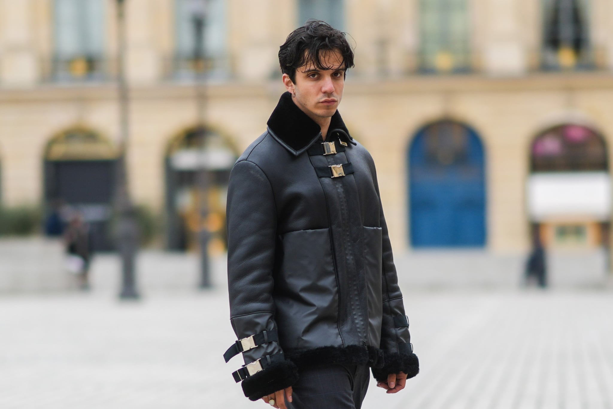 PARIS, FRANCE - APRIL 09: Alex Duarte wears silver earrings, a black shiny leather aviator coat, black pants, gold rings, black Prada Cloudbust Thunder sneakers, on April 09, 2021 in Paris, France. (Photo by Edward Berthelot/Getty Images)