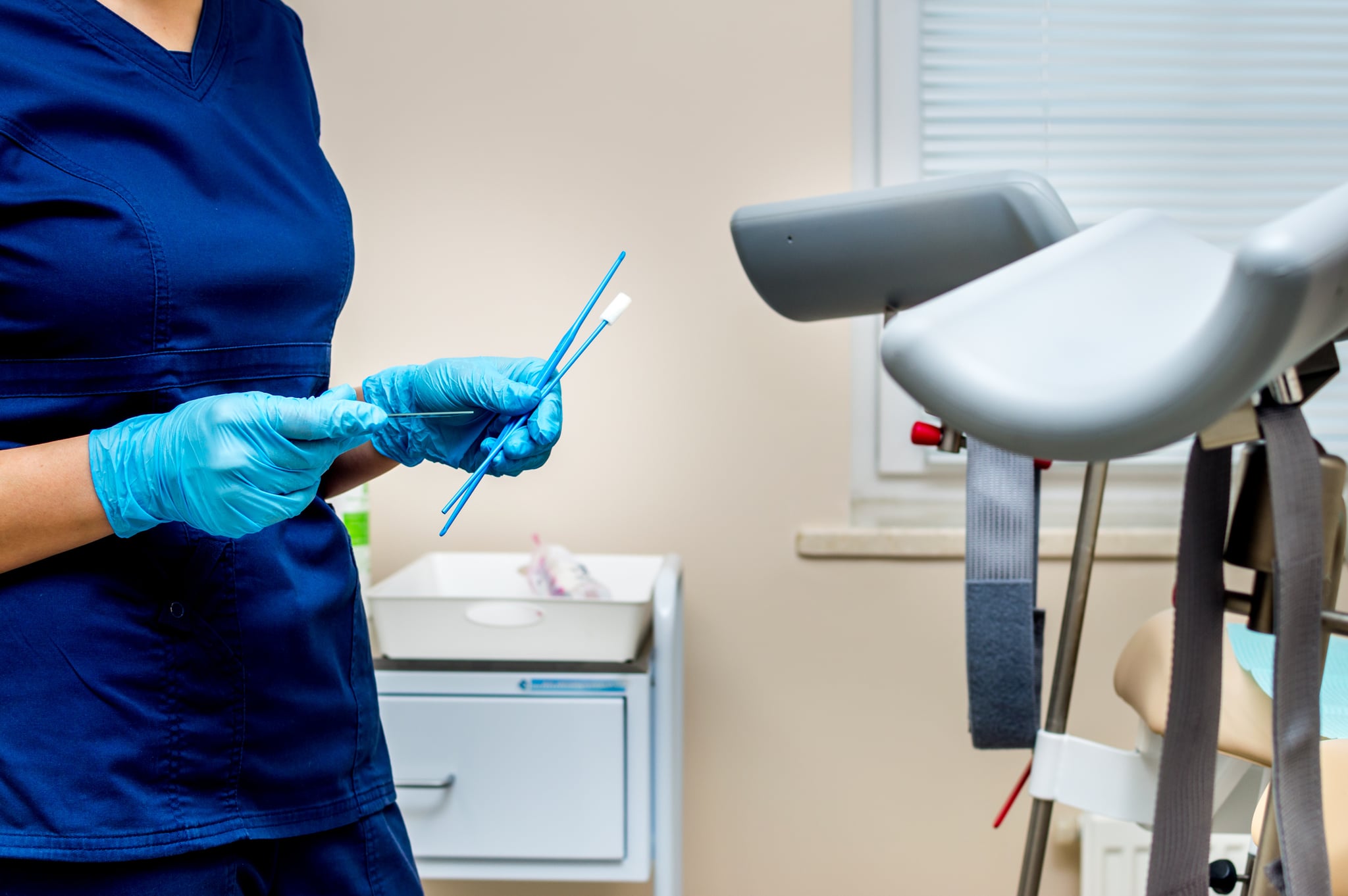 Gynecologist holds instruments for taking tests from a woman. 