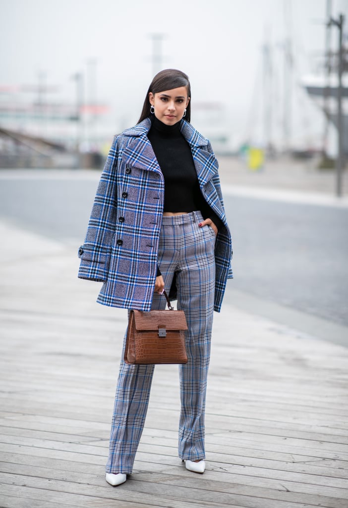 Wearing a Michael Kors peacoat, print pants, and tote at the Michael Kors show during New York Fashion Week in September 2018.