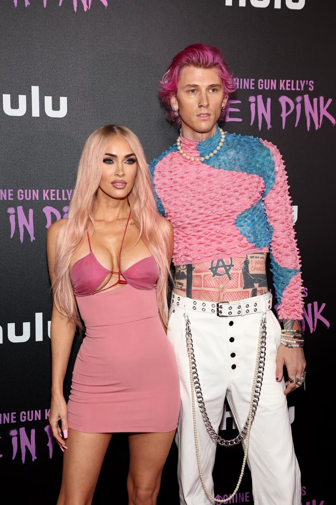 Megan Fox and Machine Gun Kelly arrived on the red carpet for the June 27 premiere of "Life in Pink," a Hulu documentary following MGK's life and career as a musician. The engaged couple were on theme and in sync as per usual, wearing coordinated bubblegum-pink looks in their usual provocative style, complete with matching hair colors. 
Styled by Maeve Reilly, Fox dressed in a pink two-toned minidress from Albanian designer Nensi Dojaka, featuring asymmetric straps and cutouts that have become the "Till Death" actor's signature. From her hair and nails down to her pedicure and strappy heels, Fox wore pink, quite literally, from head to toe. 
MGK, on the other hand, opted for a little more variation. He wore a pink-and-blue ribbed mockneck from Chet Lo, cropped to display his stomach tattoos, with white belted trousers complete with chain detailing. While the artist chose simple white sneakers as footwear, he went for drama with his jewelry choices, which included a pearl necklace, a stack of pearl bracelets, and an assortment of silver rings.
With so many couple style moments under their belts, this isn't the first time the two have matched in pink. For the "Good Mourning" premiere in May, the pair wore varying shades of the hue on the red carpet, with Fox in a blush column gown covered in rhinestones and Kelly in a fuchsia tuxedo covered in a red rose print. Since their public debut in late 2020, their outfits have continued to make headlines on both casual date nights and at splashy red carpet appearances. Check out their latest ahead.

    Related:

            
            
                                    
                            

            Megan Fox Wows at Machine Gun Kelly&apos;s Show in a 2000s-Inspired Minidress