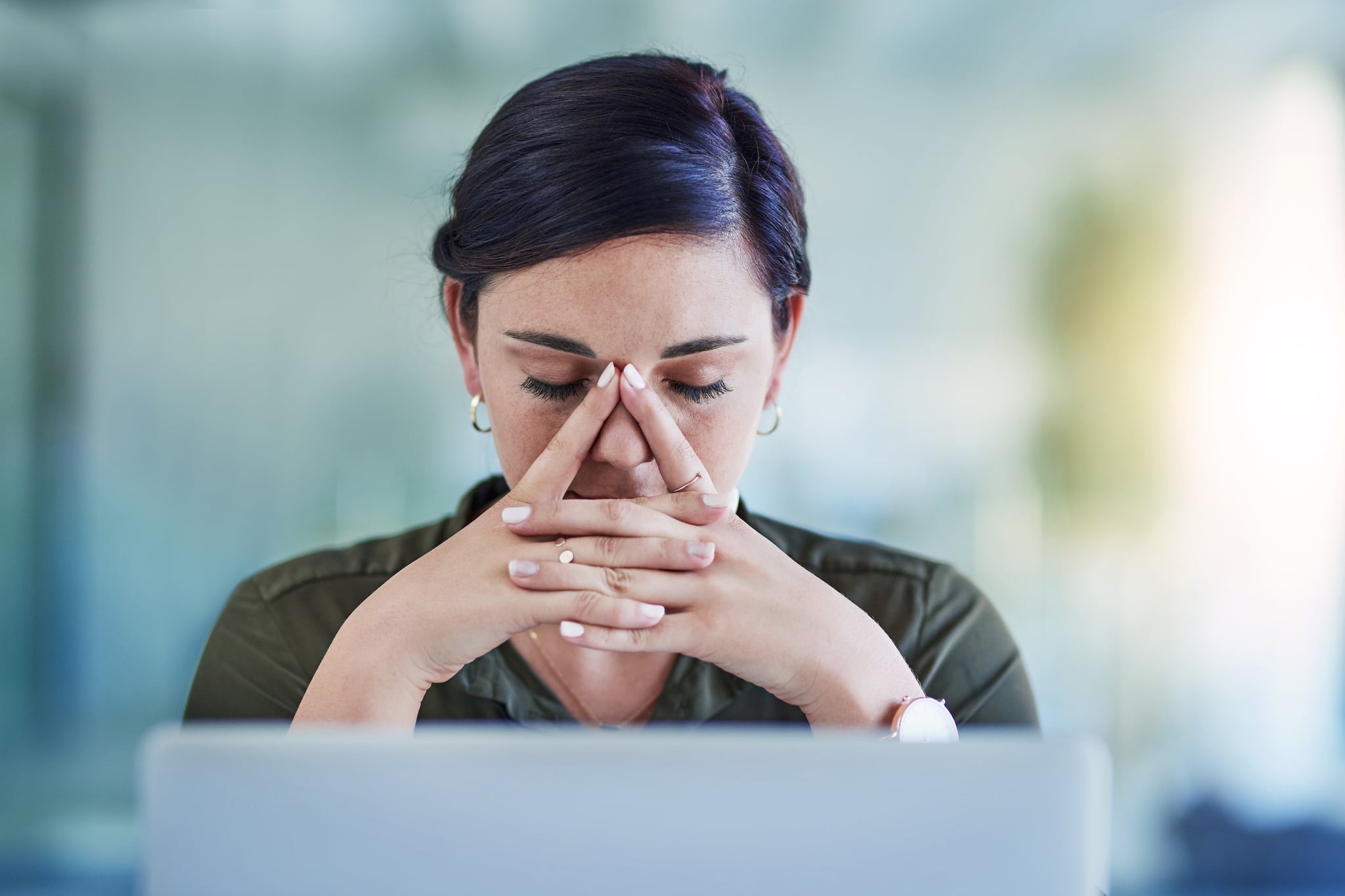 Shot of a young businesswoman looking stressed out while working in an office