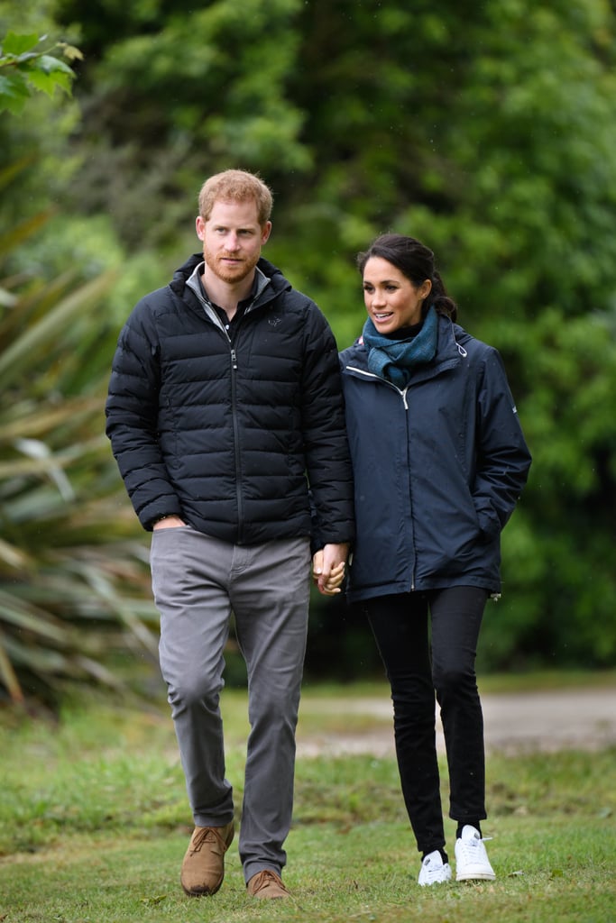 While in New Zealand, the Duchess of Sussex wrapped up in a raincoat, which she paired with black jeans, a scarf, and comfortable white sneakers by Stella McCartney for Adidas.