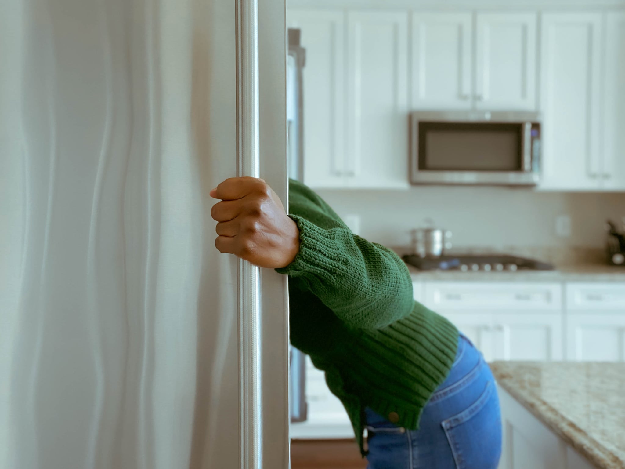 A woman searches in her fridge, wondering 'what can I make with these ingredients?' before using a recipe-generator to help her decided what to make with her ingredients.