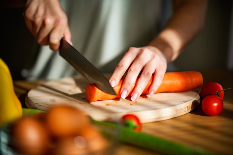 Close-up of a woman chopping vegetables in the kitchen