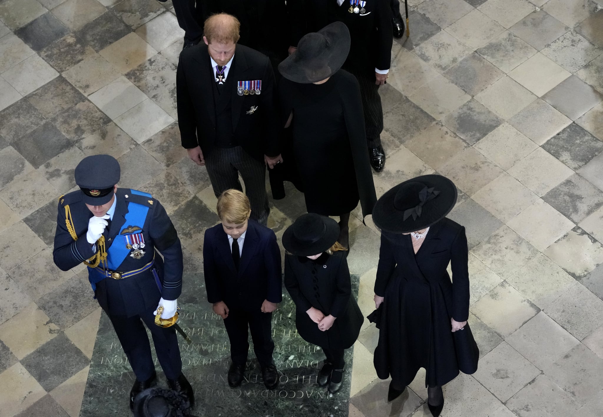 LONDON, ENGLAND - SEPTEMBER 19: (front L- R) Prince William, Prince of Wales, Catherine, Princess of Wales with their children Princess Charlotte of Wales, Prince George of Wales and (back L-R) Prince Harry, Duke of Sussex and Meghan, the Duchess of Sussex follow the coffin of Queen Elizabeth II as it is carried out of Westminster Abbey after the State Funeral on September 19, 2022 in London, England. Elizabeth Alexandra Mary Windsor was born in Bruton Street, Mayfair, London on 21 April 1926. She married Prince Philip in 1947 and ascended the throne of the United Kingdom and Commonwealth on 6 February 1952 after the death of her Father, King George VI. Queen Elizabeth II died at Balmoral Castle in Scotland on September 8, 2022, and is succeeded by her eldest son, King Charles III. (Photo by Frank Augstein - WPA Pool/Getty Images)