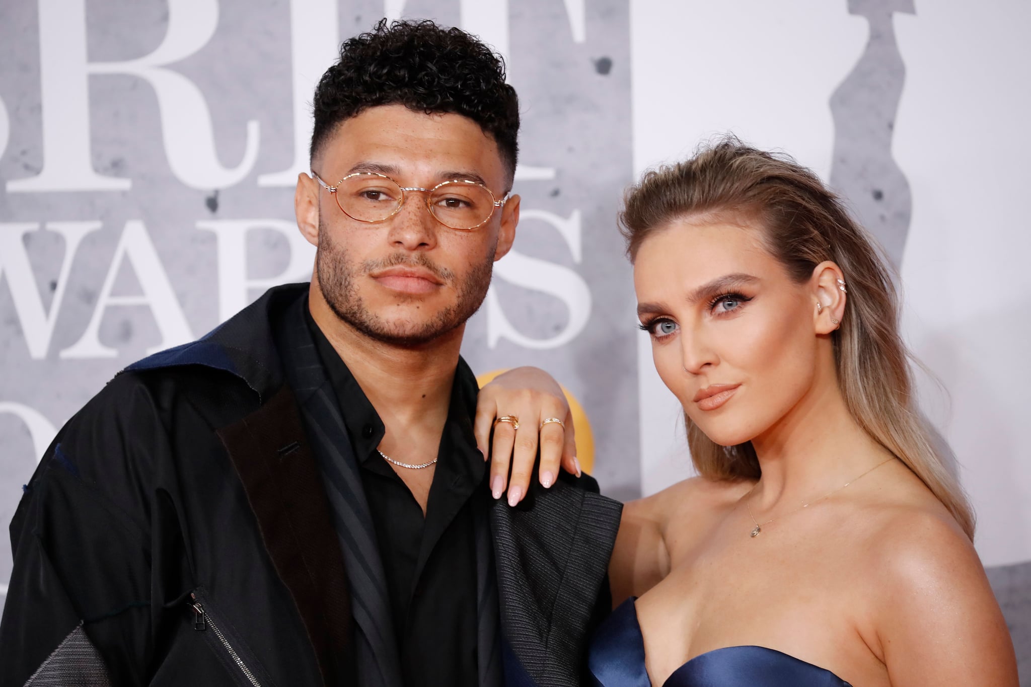 British footballer Alex Oxlade-Chamberlain and girlfriend Perrie Edwards (R) pose on the red carpet on arrival for the BRIT Awards 2019 in London on February 20, 2019. (Photo by Tolga AKMEN / AFP) / RESTRICTED TO EDITORIAL USE  NO POSTERS  NO MERCHANDISE NO USE IN PUBLICATIONS DEVOTED TO ARTISTS        (Photo credit should read TOLGA AKMEN/AFP via Getty Images)