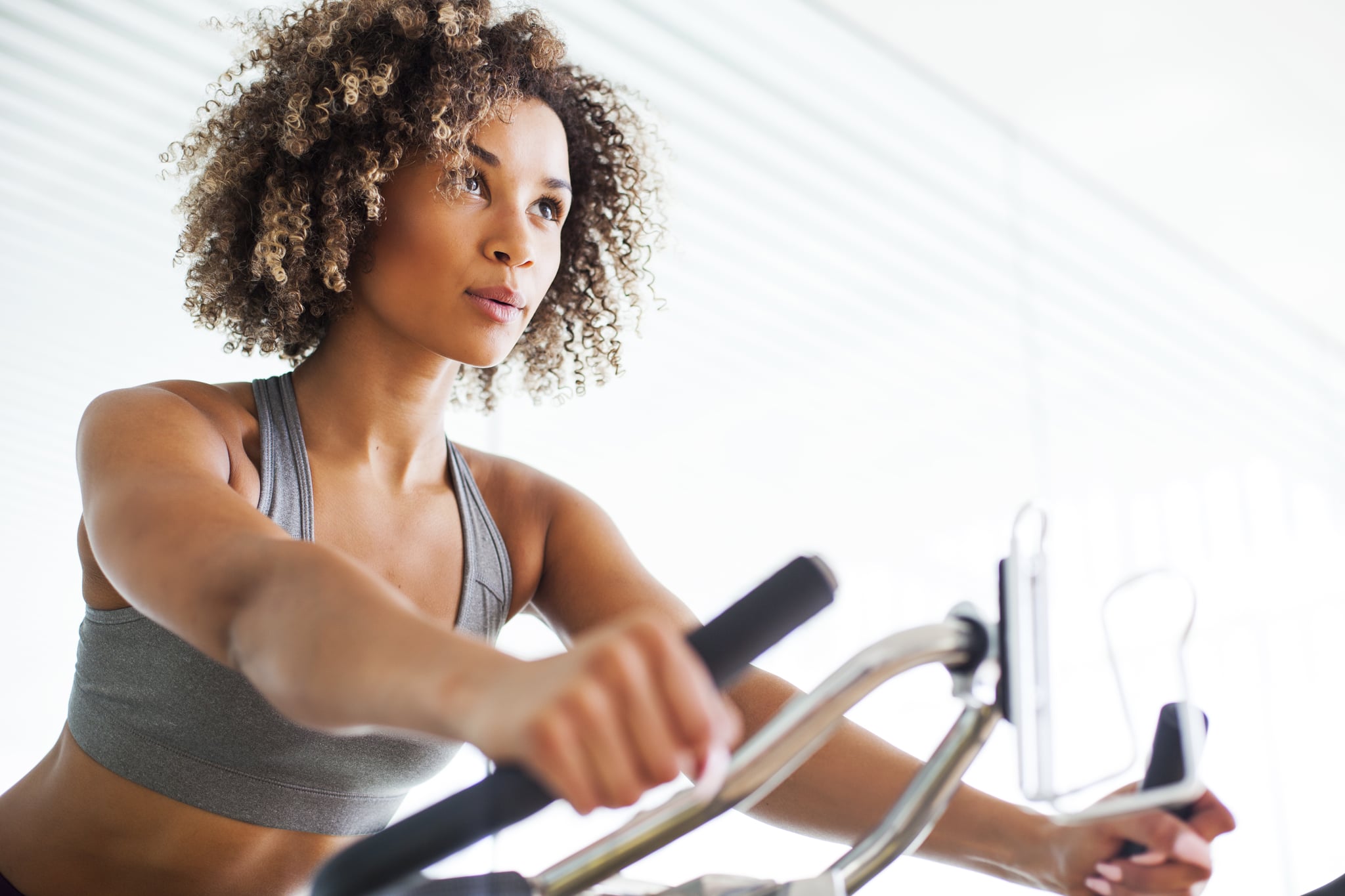 Woman Doing Cardio Exercises on a Stationary Bike at the Gym