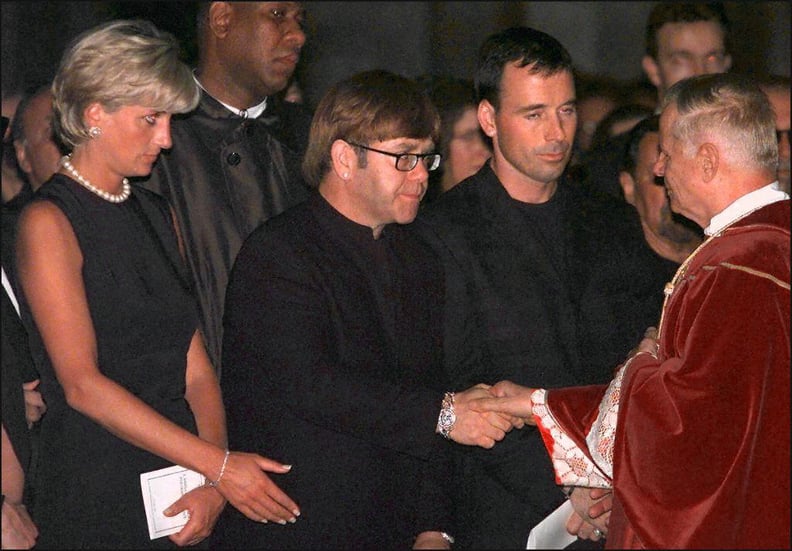 Archpriest Magio (R) shakes hands with British rock star Elton John standing next to Princess Diana (L) during the requiem mass for Italian fashion designer Gianni Versace at the Duomoin Milan 22 July 1997. Versace was gunned down in Miami Beach 15 July. 