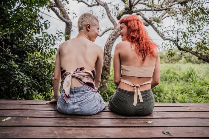 Two Lesbians Sitting Outside Facing Each Other and Smiling