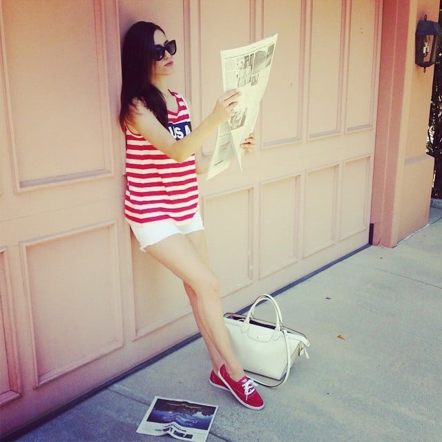 Emmy Rossum read The New York Times while sporting red, white, and