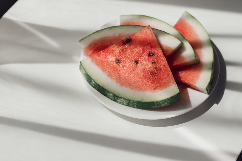Watermelon slices on white plate on the table to represent the health benefits of watermelon